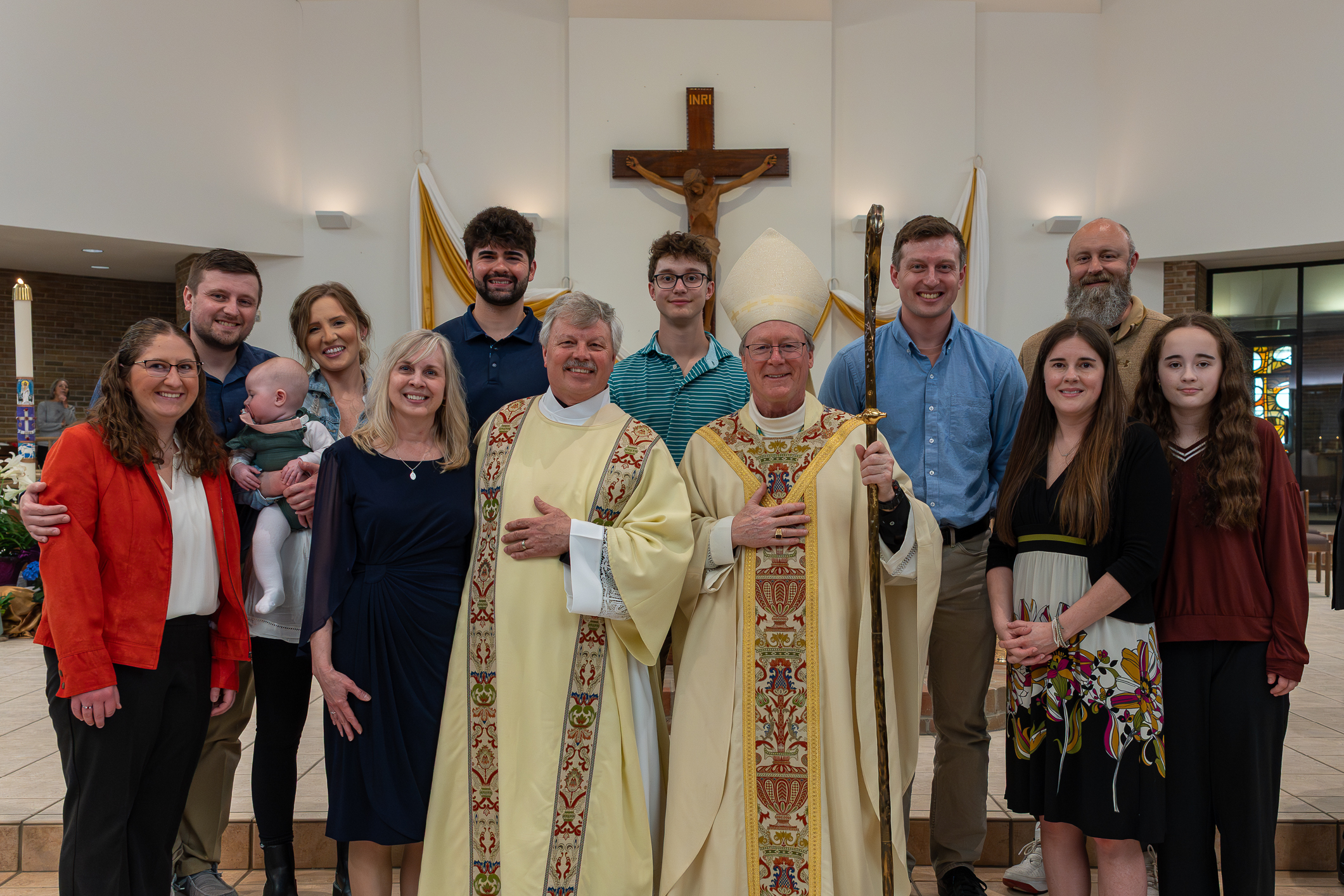 family standing with deacon and bishop