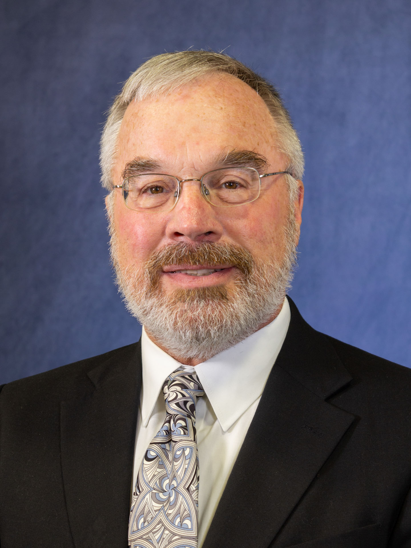gray haired man with glasses headshot
