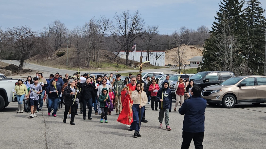 Catholics processing with cross in a parking lot