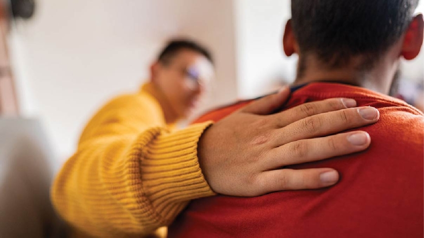 man patting young man on the back