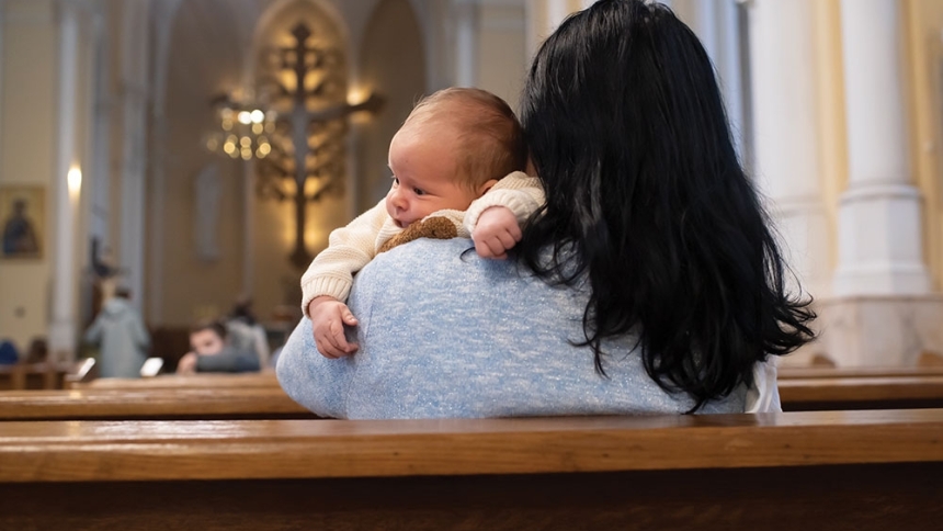 woman holding baby in church pew