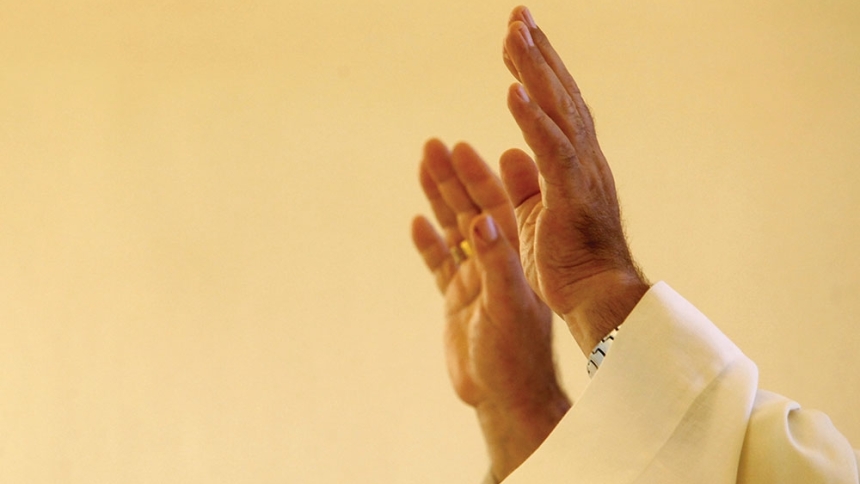 priest's hands lifted to the sky