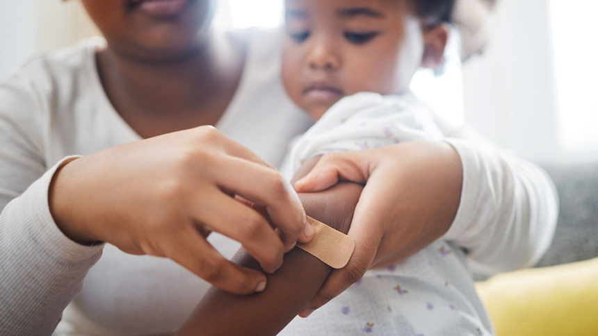 mom putting band aid on child