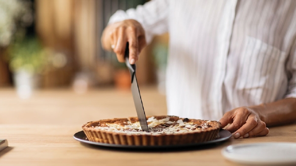 woman cutting almond dessert