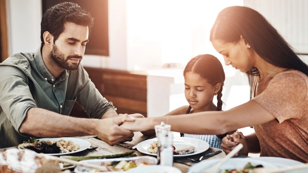 family praying before eating